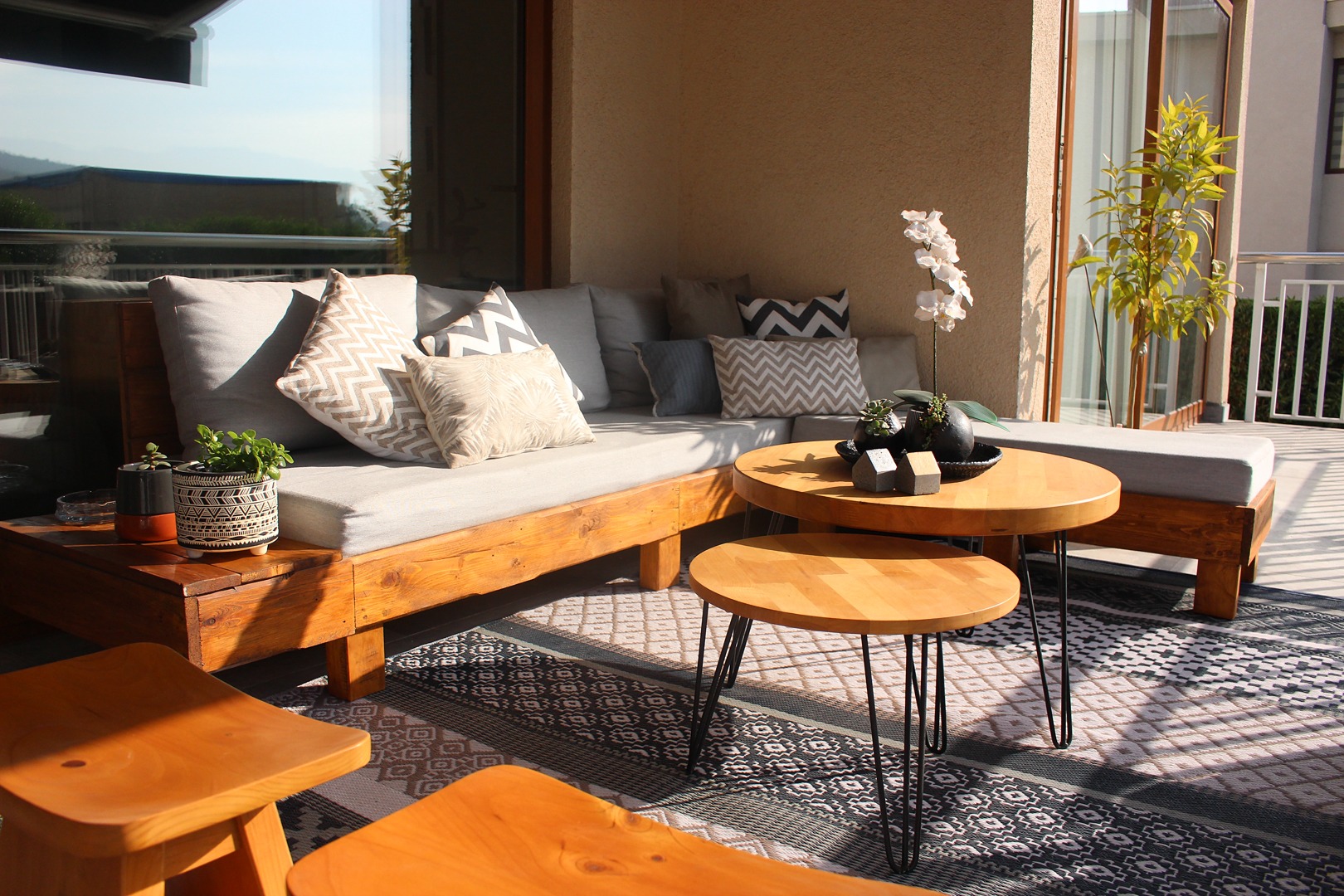 terraza_con_sofa_de_madera_de_pallet_a_medida_y_cojines_en_tela_especial_para_exterior_jpg.jpg