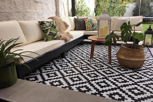 terraza_lista_sofa_en_L_alfombra_de_exterior_grande_color_negro.jpg