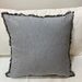 Cojines en tonos negros con blanco, grises y otros - cojin decorativo gris claro con flecos cuadrado.jpeg