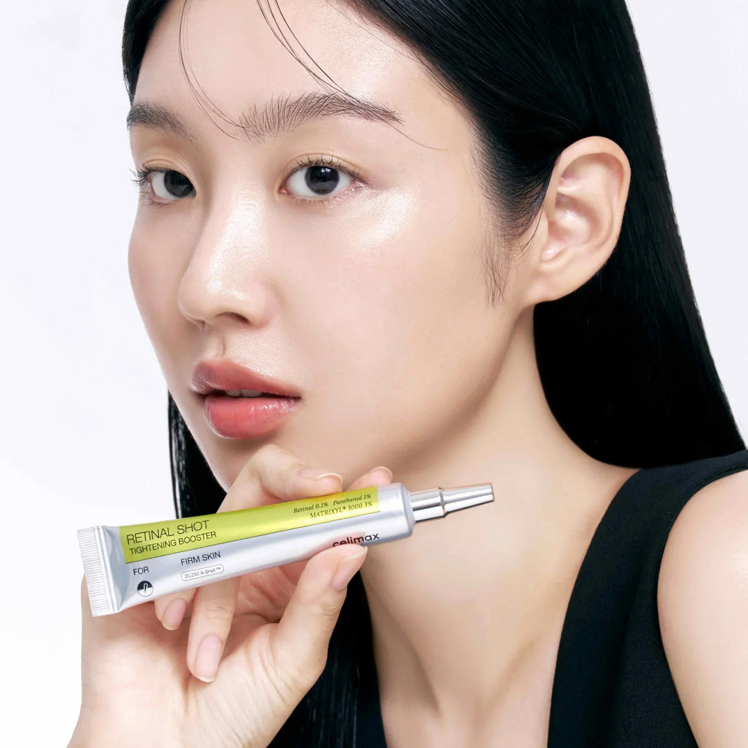 Modelo sostiene el tubo de Celimax Retinal Shot Tightening Booster 15ml, booster coreano de noche para piel de aspecto más firme.