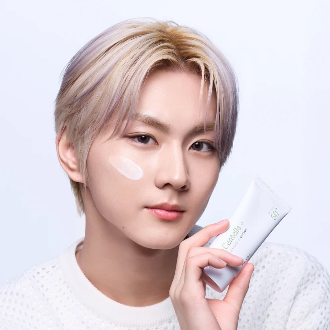 Modelo sostiene el tubo de Mixsoon Centella Sun Cream junto a su rostro.