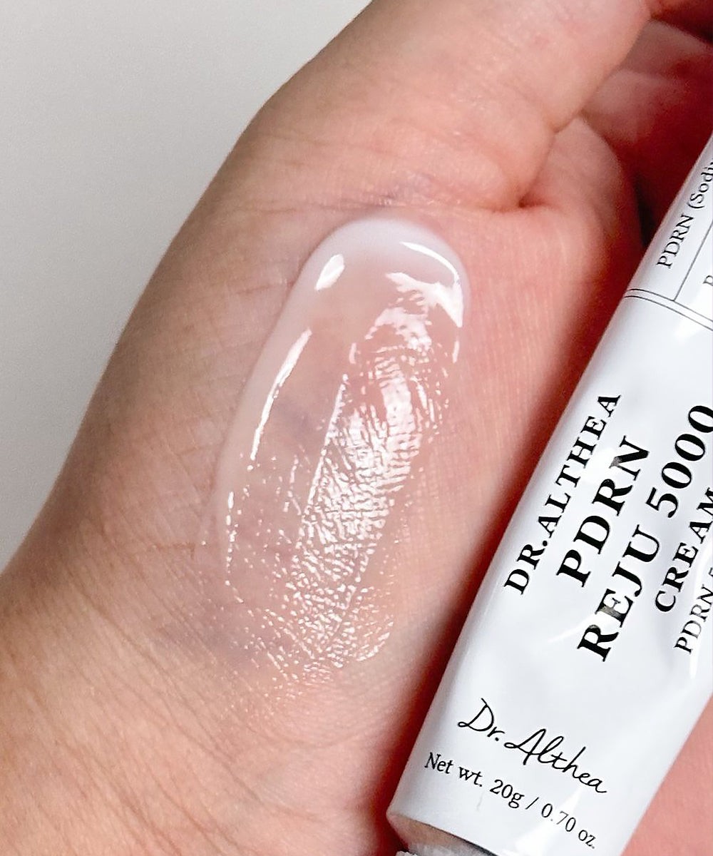 Textura ligera de Dr.Althea PDRN Reju 5000 Cream extendida sobre el dorso de la mano junto al tubo.