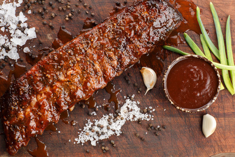 Costillar Baby Back Ahumado con Salsa Barbecue en una tabla