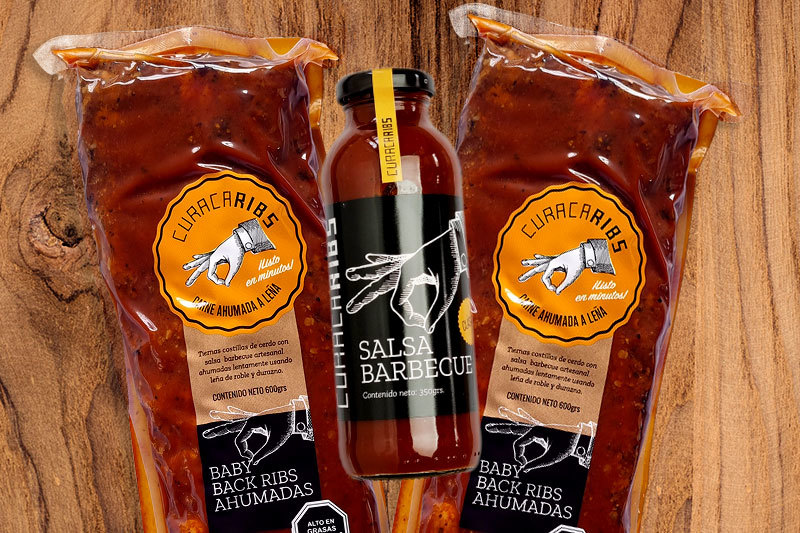 Dos costillares barbecue ahumados junto a una botella de salsa barbecue artesanal
